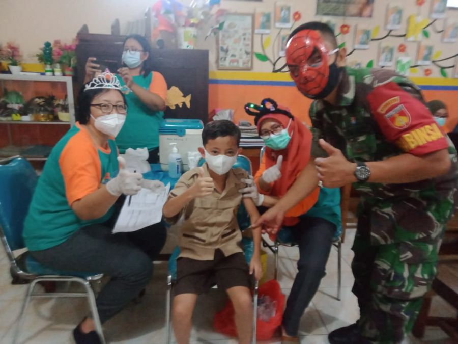 Babinsa Memakai Topeng Spiderman Menarik Minat Siswa Dalam Acara Vaksinasi